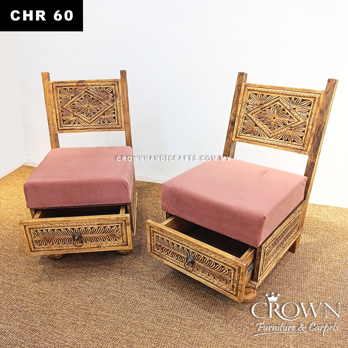 Two carved wooden low chairs with open storage space under pink seat cushions