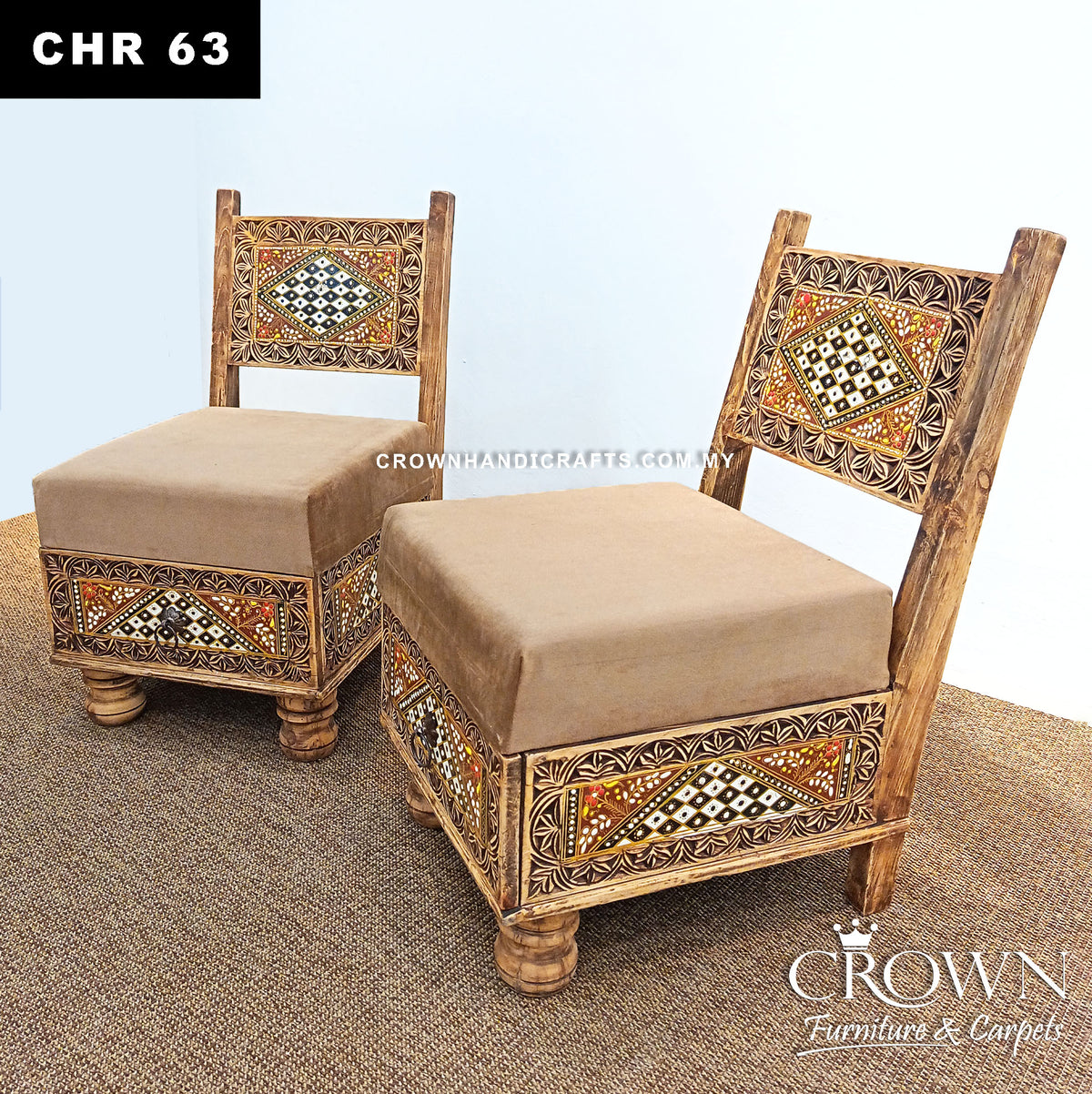 Two low wooden accent chairs angled view, beige cushions and decorative Rajasthani panels