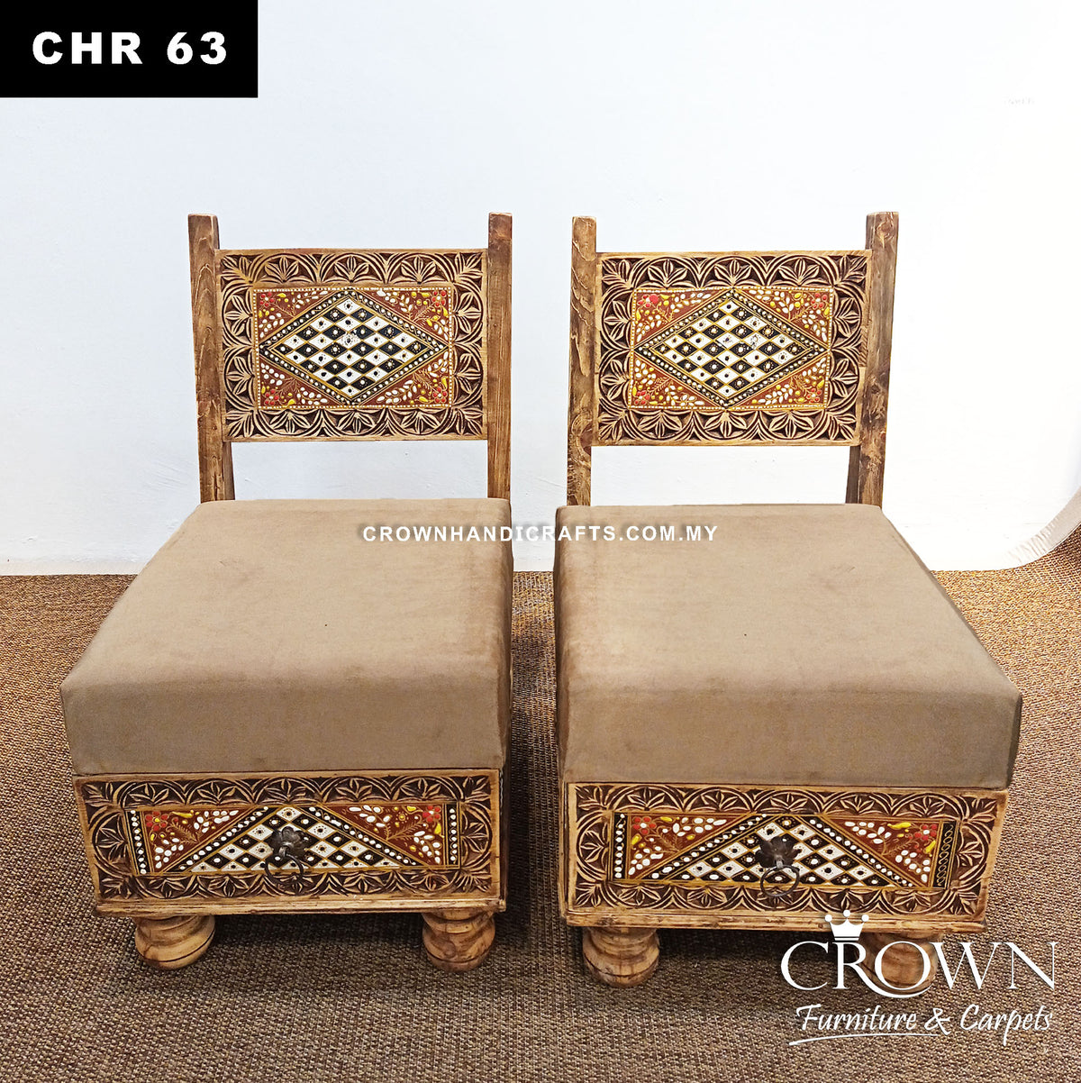 Pair of low wooden chairs with beige seat cushions and carved Rajasthani geometric panels