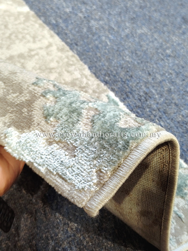 Runner rug corner detail with cream-and-light-blue abstract pattern, bound edge