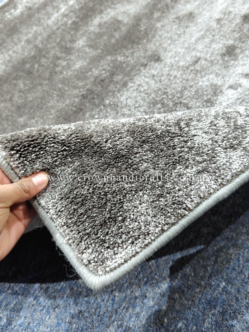 Dark gray runner rug with low pile texture and stitched border, corner folded up