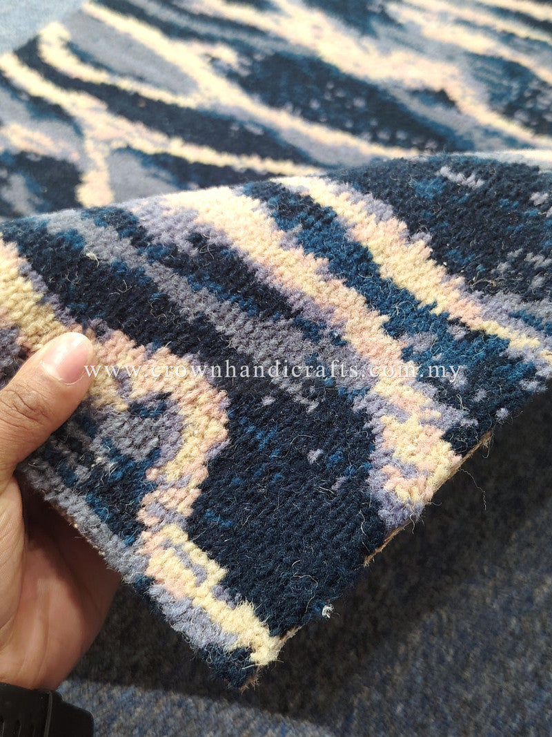 Close-up corner of wave-pattern runner rug with navy, cream, and pale yellow stripes.