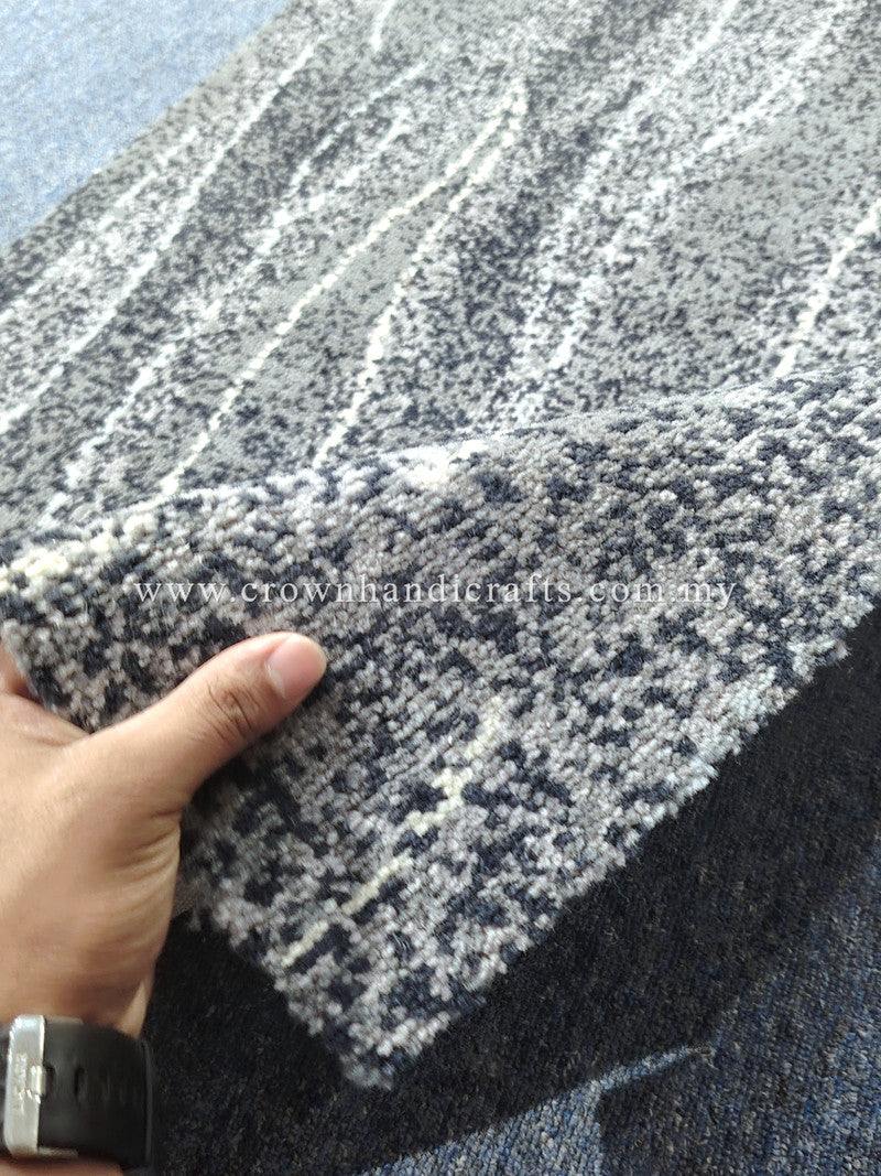 Abstract runner rug with charcoal and cream geometric pattern, corner close-up with hand
