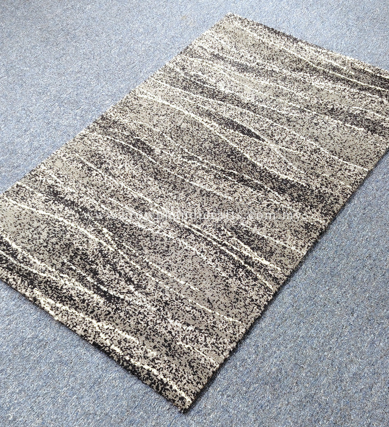 Abstract area rug with light beige and dark speckled stripes, diagonal perspective