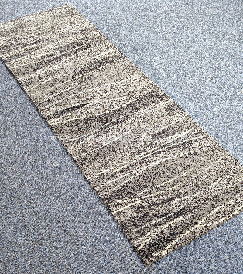Hallway runner rug with beige background and dark speckled abstract stripe pattern, short pile
