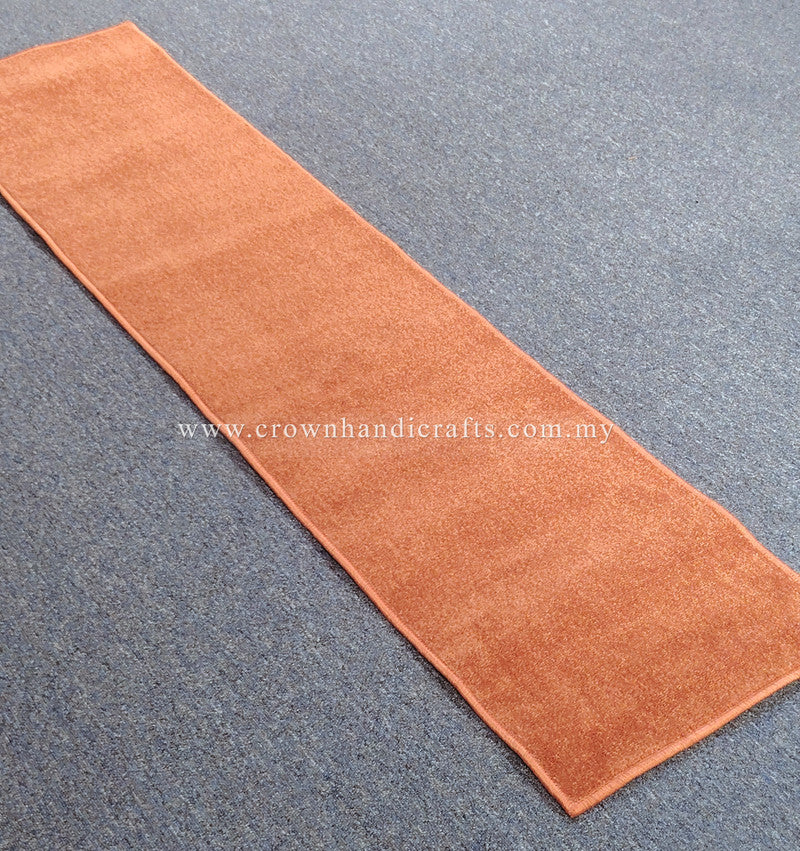 Rust velvet runner rug laid flat, even plush pile with stitched border