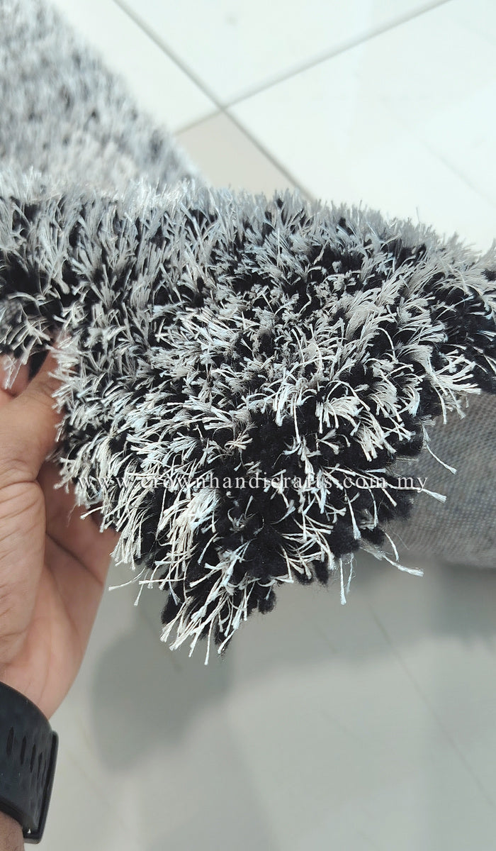 Shaggy runner rug, black-and-white pile, close-up of thick fibers held in hand
