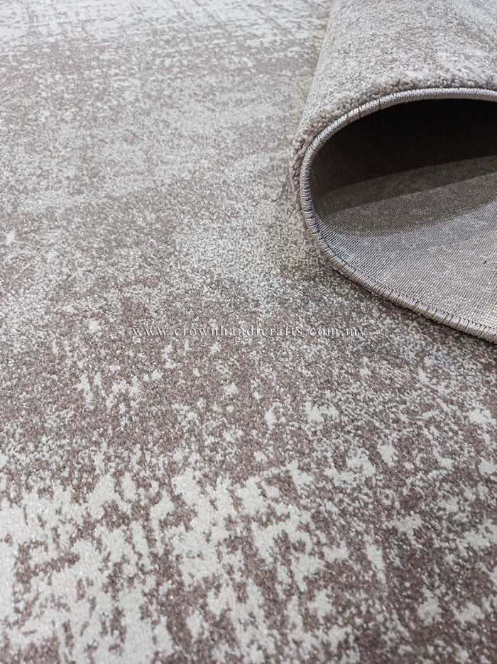 Abstract area rug with distressed beige and white pattern, rounded rolled edge.