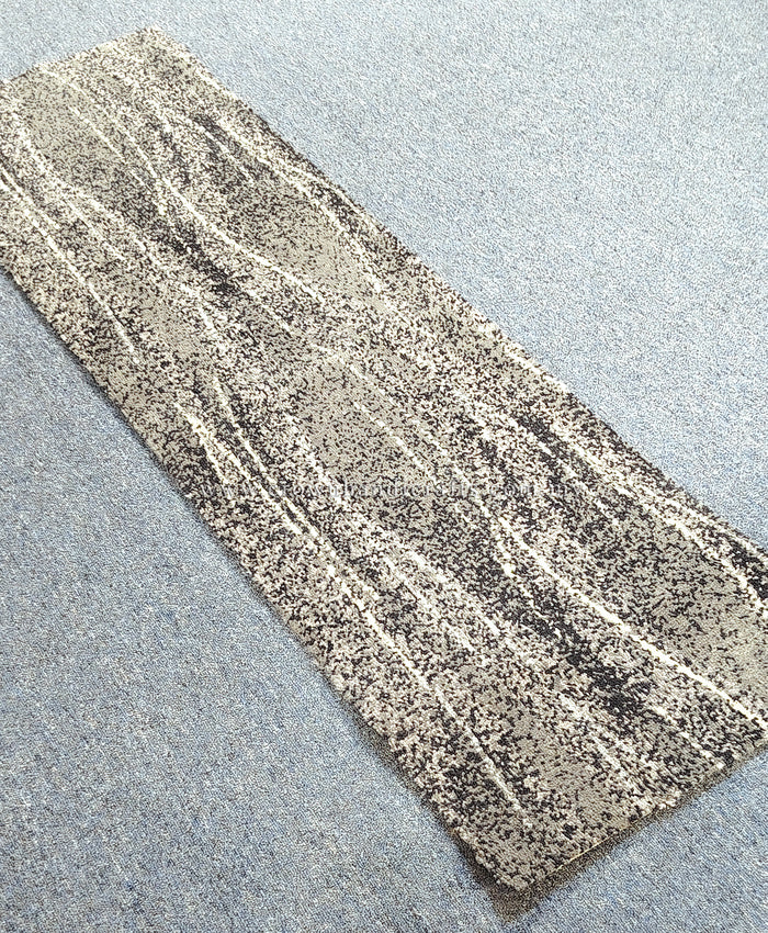 Abstract narrow runner rug with beige and gray mottled stripe pattern, flat on floor