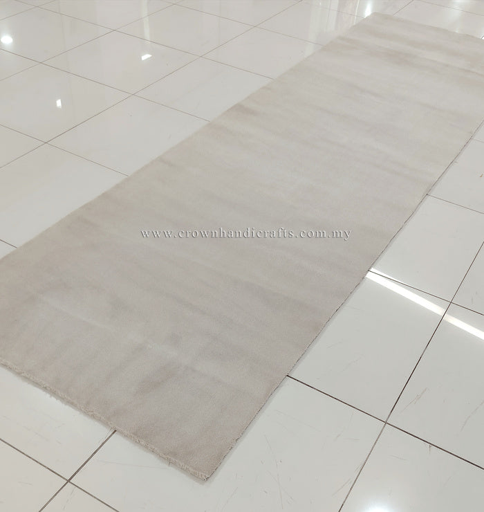 Oatmeal beige long runner rug with low, even pile; plain surface and short fringe.