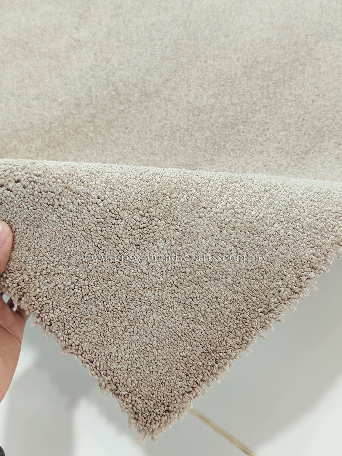 Shaggy accent rug with short plush pile, light beige color at a corner edge