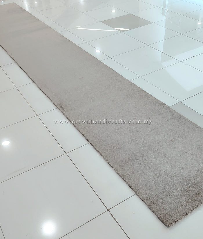 Taupe long shaggy runner rug laid on tile floor, wide rectangular shape