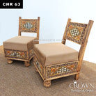 Two low wooden accent chairs angled view, beige cushions and decorative Rajasthani panels