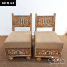 Pair of low wooden chairs with beige seat cushions and carved Rajasthani geometric panels