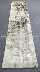 Beige runner rug with dark abstract patches, short plush texture