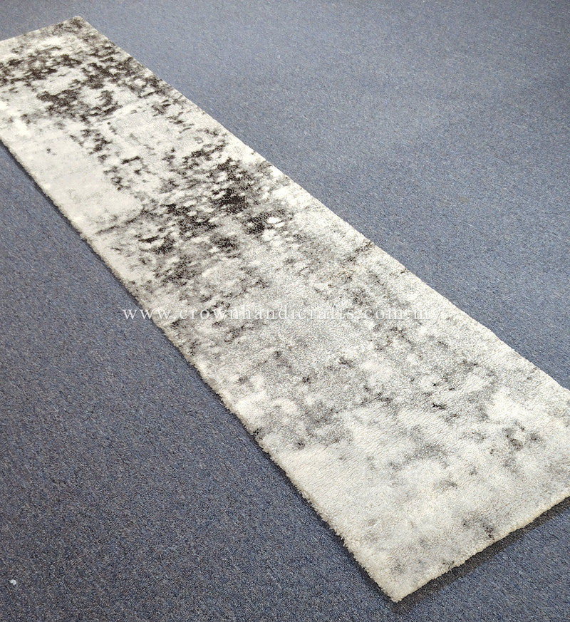 Light beige runner rug with dark mottled abstract pattern, short plush pile