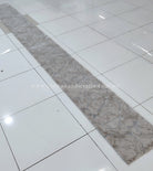Extra-long beige runner rug with mottled abstract design and low, dense pile