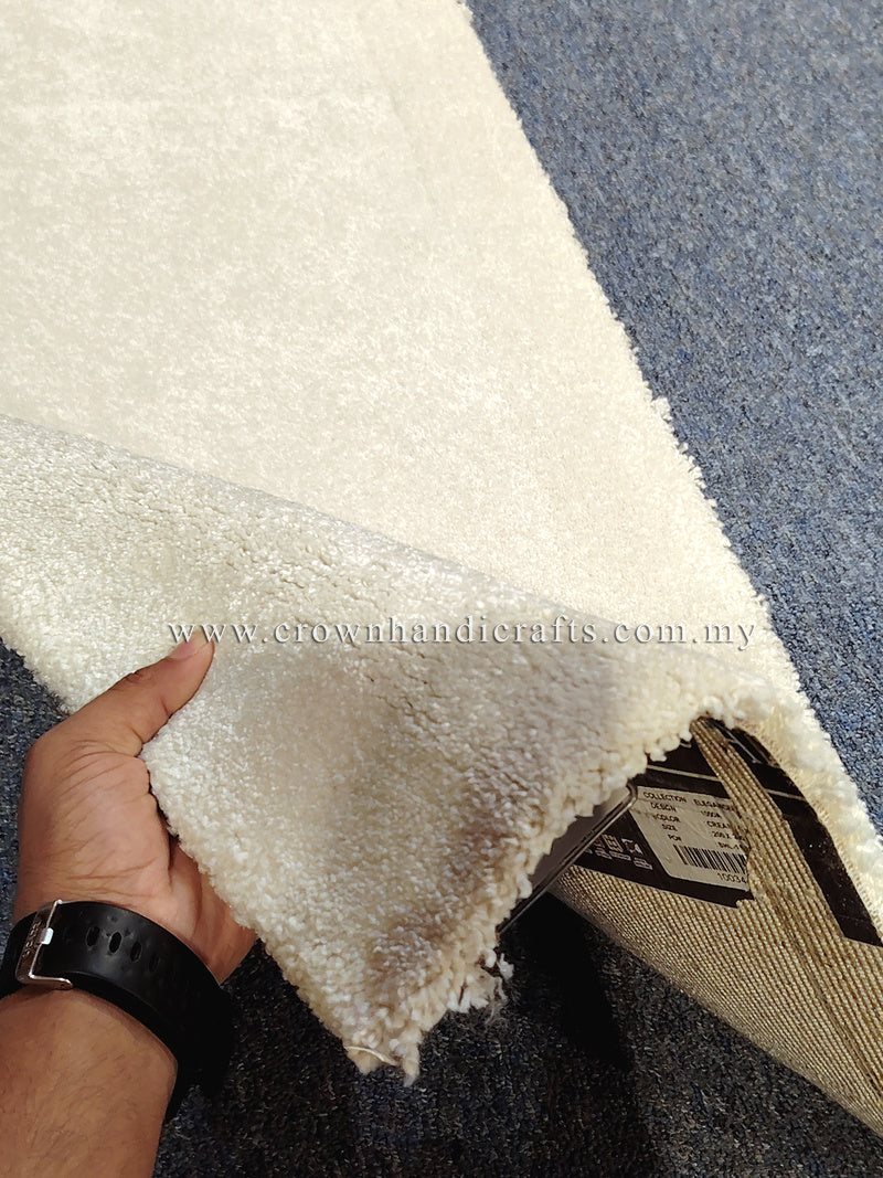 Cream runner rug corner close-up, showing soft textured pile and backing tag.