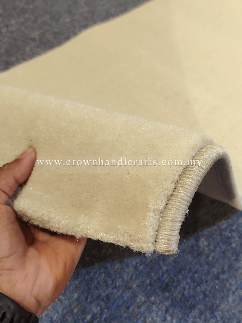 Cream runner rug corner with stitched binding and plush pile, close-up
