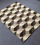 Geometric square area rug with repeating cube pattern in black, white and beige, angled view.