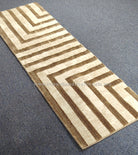Beige hallway runner rug featuring brown and cream chevron stripe design