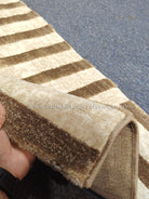 Beige and cream hallway runner rug with brown stripe pattern and stitched border