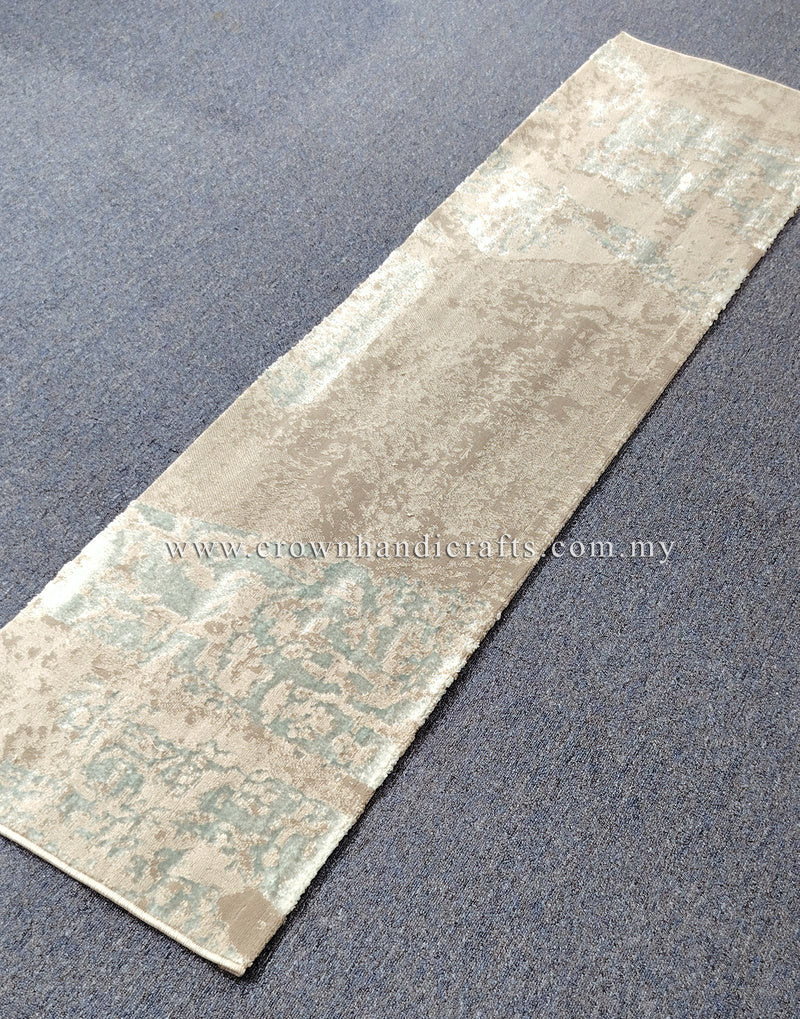 Beige runner rug laid flat with light teal faded patchwork pattern