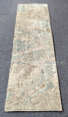 Runner rug with cream base and light blue abstract pattern, trimmed edge
