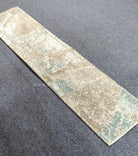 Slim runner rug laid flat, cream base with light blue abstract pattern
