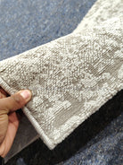 Close-up of runner rug texture: cream pile with light blue abstract pattern