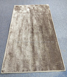 Beige runner rug with speckled sheen and centered distressed pattern, bordered edges
