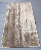 Beige runner rug with shimmering mottled finish and detailed perimeter border