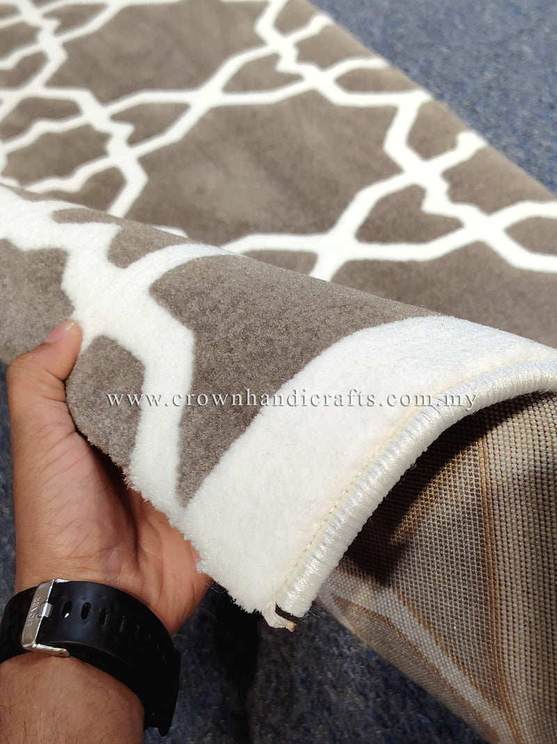 Close-up of grey-brown runner rug edge with white lattice design and textured pile.