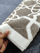 Modern runner rug with white lattice pattern on grey-brown ground, short fringed edge.