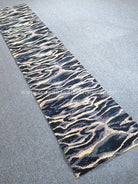 Modern runner rug with navy and beige wave-pattern texture, flat woven look.