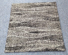 Abstract accent rug with beige base and black, gray horizontal wave stripes