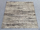 Speckled abstract rug with beige base and black, gray horizontal stripe pattern