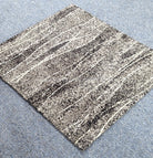 Speckled abstract rug corner with beige, dark gray, and light stripe lines