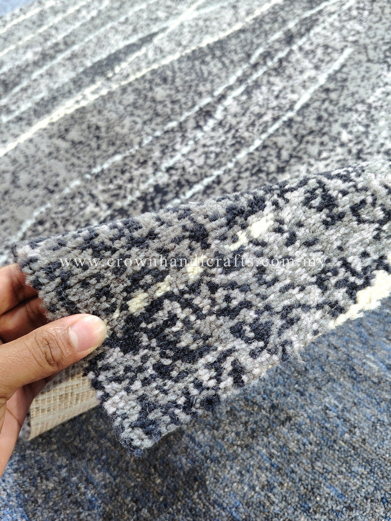 Abstract gray-blue rug with speckled navy and white stripe pattern, edge detail