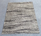 Abstract area rug centered, cream and dark charcoal horizontal striations pattern