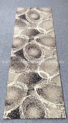 Abstract runner rug with large circular motifs, light beige base and dark speckles
