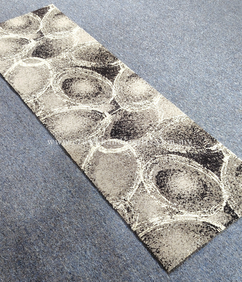 Diagonal view of abstract runner rug with oval and circular linework on beige-gray