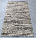 Abstract striped area rug with cream and charcoal speckled bands in a rectangular shape