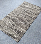 Abstract striped area rug with cream and dark gray/black flecked lines
