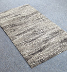 Abstract striped area rug, cream base with dark speckled horizontal bands