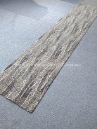 Extra-long abstract runner rug laid diagonally, gray and cream wavy line pattern