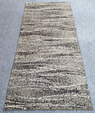 Abstract runner rug with beige ground and dark speckled striping, full rug view