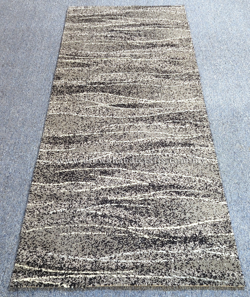 Abstract runner rug with beige ground and dark speckled striping, full rug view