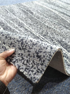 Runner rug with abstract gray-and-beige striped pattern, textured pile edge visible