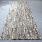 Abstract floor rug, light beige with white flowing line pattern; full rug view.